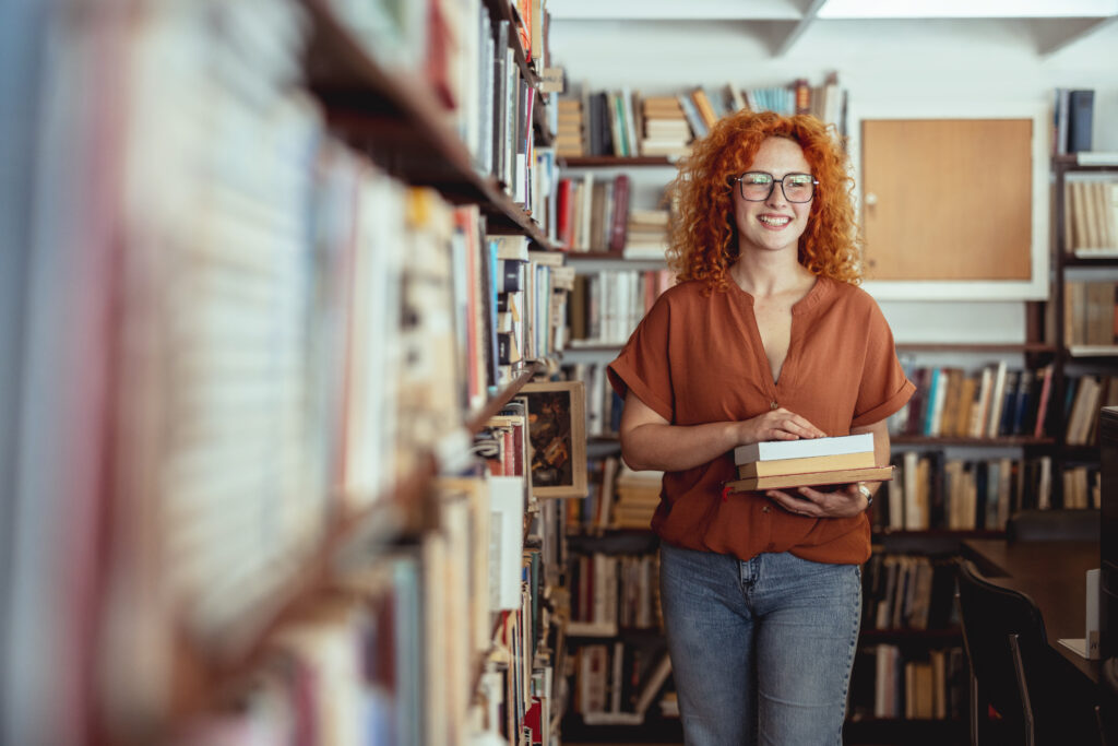 Woman Reading Book in a Library for Education, Studying and Research in School, University or College Campus
